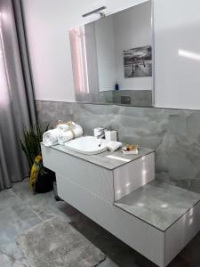 La salle de bains est pourvue d'un lavabo blanc et d'un miroir. dans l'établissement B&B LA ROSA GIALLA, à Maranello