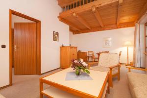 a living room with a vase of flowers on a table at Gschwendtnerhof Böhm Appartement 22 in Aschau im Chiemgau