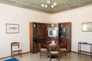 een woonkamer met een tafel en stoelen en een televisie bij Palazzo Baffo - Residenza storica , Chioggia in Chioggia