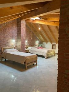 a room with two beds and a brick wall at Il Giglio Affittacamere in Tortolì