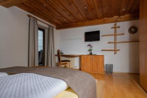 a bedroom with a bed and a desk with a television at Ferienwohnung Gaigg in Weyregg