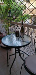 una mesa con una botella de vino y dos copas en Cozy ACROPOLIS, en Atenas