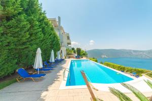 una piscina en un hotel con sillas y sombrillas en Skroponeria View Apartments en Skroponeria