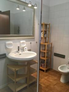 y baño con lavabo, espejo y aseo. en Le Camere di Garibaldi en Borgomanero