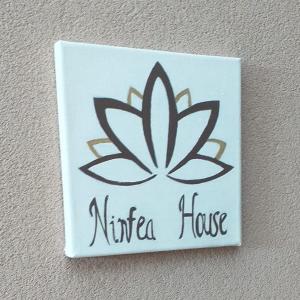 a sign on a wall with a nirica house at NINFEA HOUSE in Marina di Montenero