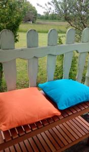 a bench with an orange cushion and a blue pillow at LA PARENTHESE in Villeret