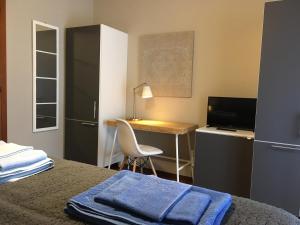 - une chambre avec un bureau et un lit avec une serviette bleue dans l'établissement Le Camere di Garibaldi, à Borgomanero