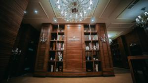 a book shelf in a room with a chandelier at JELSOMINOHotel in Astana