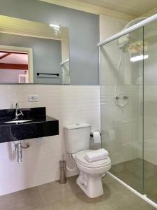 a bathroom with a toilet and a sink and a shower at Suite Lavanda in Santo Antônio do Pinhal