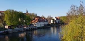 un río con edificios al lado de una ciudad en Tipp - Halle idyllisch am Fluss, en Kröllwitz