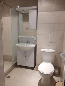La salle de bains est pourvue de toilettes blanches et d'un lavabo. dans l'établissement Студио-"Ziko", à Pomorie