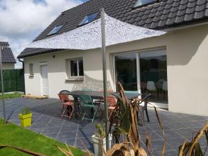 un patio con mesa y sillas en una casa en Gites Le John Jeffries - Le Grand Jeff, en Guînes