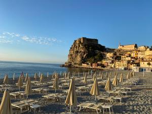 a bunch of beach chairs and umbrellas on a beach at Casa Vacanze Antares in Scilla