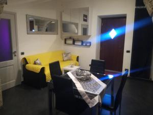 a living room with a table and a yellow couch at Monti di bò in Aggius