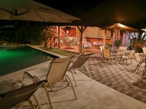 a group of chairs and umbrellas next to a pool at Hostel Antorchas in Dominical
