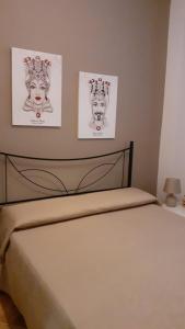 a bedroom with two pictures on the wall and a bed at Casa Vacanze Chiara in Terrasini