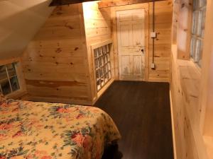 a bedroom in a log cabin with a bed at Riverhouse in South Berwick