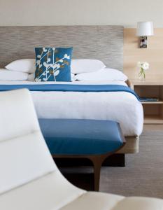 a bedroom with a large bed with blue and white pillows at Hyatt Regency Long Beach in Long Beach