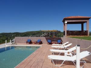 a group of lounge chairs next to a swimming pool at MELILOFOS STUDIO 1 BDR w Pool in Evia island in Avlonárion