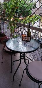 una mesa de cristal con una botella de vino. en Cozy ACROPOLIS, en Atenas