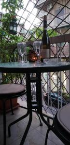 una mesa con dos copas y una botella de vino en Cozy ACROPOLIS, en Atenas