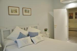 sypialnia z białym łóżkiem z poduszkami w obiekcie The Avalon w Rzymie