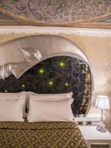 sypialnia z łóżkiem z zagłówkiem delfina w obiekcie EGO' Boutique Hotel - The Silk Road w Wenecji