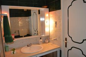 W łazience znajduje się umywalka i lustro. w obiekcie Apartamento Eden w mieście Monte Gordo