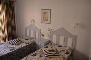a bedroom with two twin beds and a dresser at Apartamento Eden in Monte Gordo