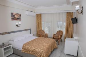 a hotel room with a bed and two chairs at Hali Hotel in Istanbul