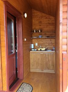 an empty room with a kitchen in a wooden cabin at Cristal de Sare in Praid