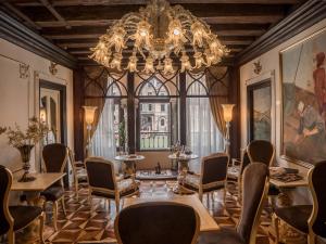 Habitación grande con lámpara de araña, mesas y sillas. en EGO' Boutique Hotel - The Silk Road, en Venecia