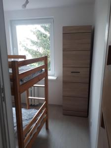 Cette chambre dispose d'une échelle, d'une fenêtre et d'une commode. dans l'établissement Małe przytulne mieszkanie, à Mrągowo