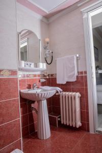 a bathroom with a sink and a mirror and a radiator at Hali Hotel in Istanbul