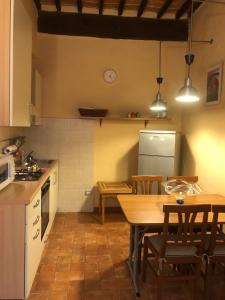 una cucina con tavolo, sedie e frigorifero di Casa di Silvia a Città di Castello