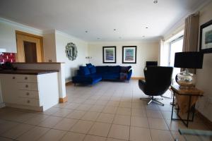 - un salon avec un canapé bleu et une table dans l'établissement Seventeen Carrig Na Rone, à Portrush