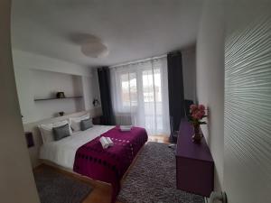 a bedroom with a bed and a vase of flowers at Chic Apartament in Deva