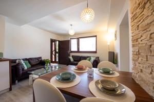 - une salle à manger et un salon avec une table et des chaises en bois dans l'établissement Apartman MANDALA, à Banská Bystrica