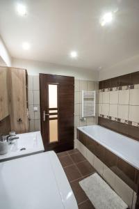 a large bathroom with a tub and a sink at Apartman MANDALA in Banská Bystrica