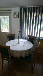 einen Esstisch mit einer Blumenvase darauf in der Unterkunft Holiday house near the see in Luka