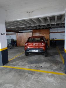 un pequeño coche rojo estacionado en un estacionamiento en Apto. en Edif. Antibes. Hermoso entorno, en Punta del Este