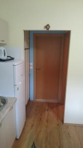 a kitchen with a brown door and a wooden floor at Holiday house near the see in Luka