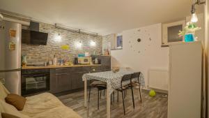 una cocina con una mesa con sillas y una cocina con encimera en Prime Residence, en Brasov