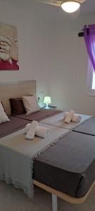 two large beds in a room with purple curtains at APARTAMENTOS BINIFORCAT CB apto 52 IDEAL PLACE FOR HOLIDAY in Cala en Blanes