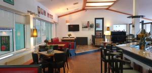 a restaurant with tables and chairs and a bar at Sporthotel Papenburg in Papenburg