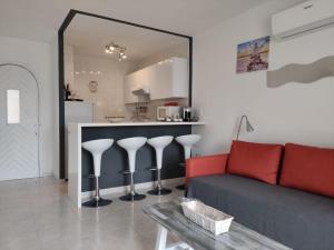 a living room with a red couch and a kitchen at APARTAMENTOS BINIFORCAT CB apto 52 IDEAL PLACE FOR HOLIDAY in Cala en Blanes