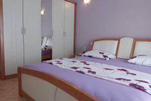 Un dormitorio con una cama grande con una manta morada. en Beautiful apartment 80 m from the sea, en Marusici 