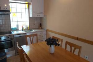 Una cocina con una mesa de madera con un jarrón de flores encima. en Beautiful apartment 80 m from the sea, en Marusici  17 fotos más
