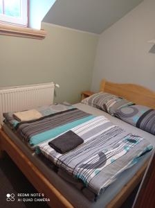 a bed with a blanket on it in a bedroom at Apartamenty w Karkonoszach in Lubawka