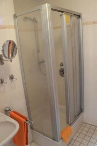 a shower with a glass door in a bathroom at Sporthotel Papenburg in Papenburg